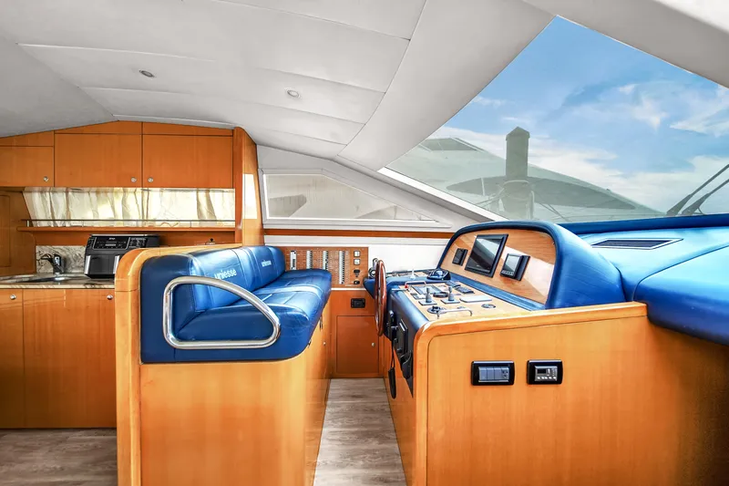  Yacht Photos Pics Interior of 2006 Uniesse 58 yacht with blue leather seating and wooden cabinetry.