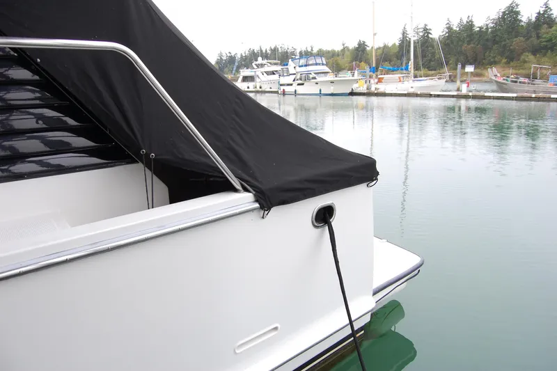 Sumptin Special Yacht Photos Pics 1990 Ocean Alexander 520 Pilothouse docked at marina, covered with black tarp.