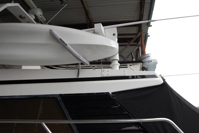 Sumptin Special Yacht Photos Pics 1990 Ocean Alexander 520 Pilothouse yacht with Honda outboard motor, docked under shelter.