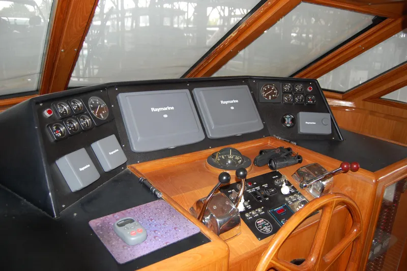 Sumptin Special Yacht Photos Pics Pilothouse of 1990 Ocean Alexander 520, featuring Raymarine navigation equipment and wooden steering wheel.