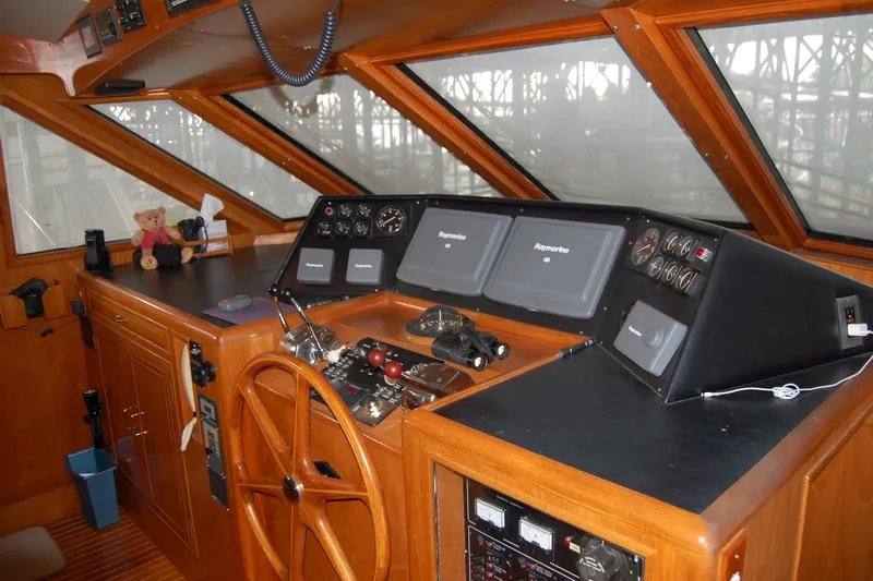 Sumptin Special Yacht Photos Pics Pilothouse interior of 1990 Ocean Alexander 520, featuring navigation equipment and wooden steering wheel.