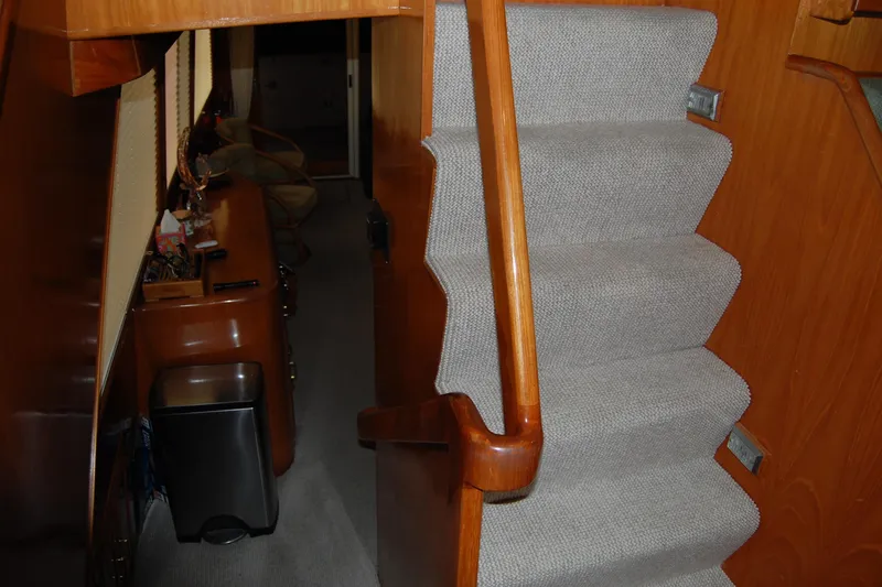 Sumptin Special Yacht Photos Pics Interior stairs of 1990 Ocean Alexander 520 Pilothouse with wooden handrail and carpeted steps.