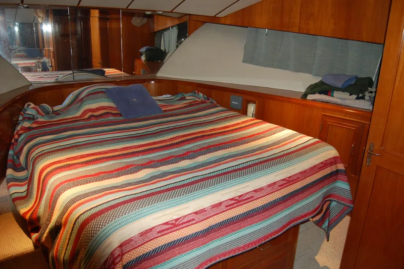 Sumptin Special Yacht Photos Pics Cozy bedroom in 1990 Ocean Alexander 520 Pilothouse with striped bedding and wooden cabinetry.