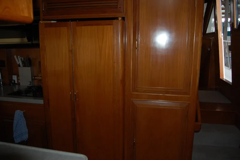 Sumptin Special Yacht Photos Pics Interior of 1990 Ocean Alexander 520 Pilothouse with wooden cabinetry and kitchen area.