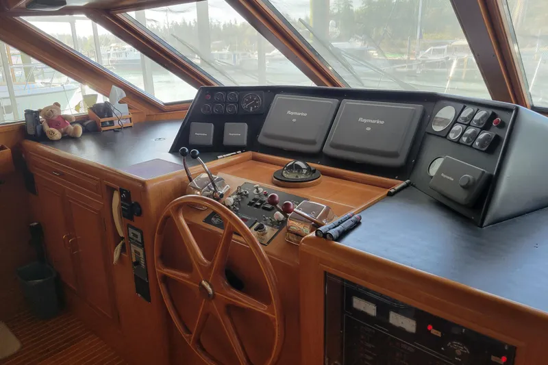 Sumptin Special Yacht Photos Pics Pilothouse interior of 1990 Ocean Alexander 520, featuring navigation equipment and wooden steering wheel.