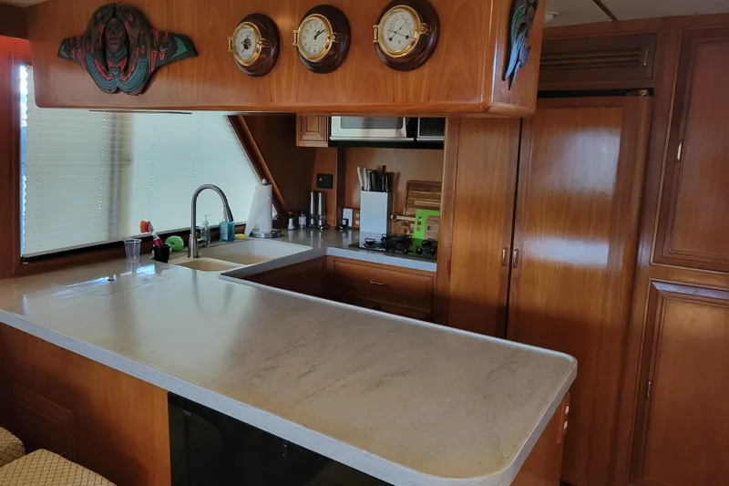 Sumptin Special Yacht Photos Pics Interior of 1990 Ocean Alexander 520 Pilothouse with wooden cabinetry and modern kitchen amenities.
