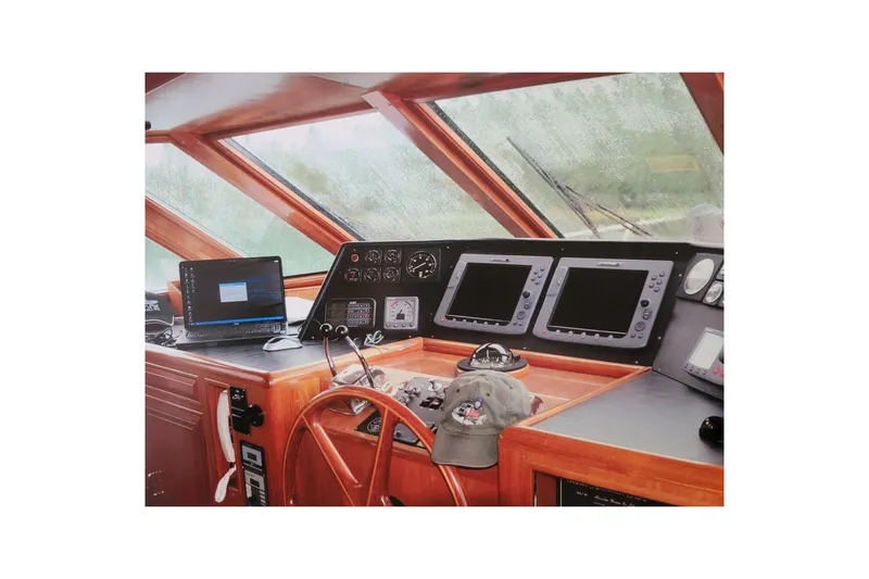 Sumptin Special Yacht Photos Pics Pilothouse interior of 1990 Ocean Alexander 520, featuring navigation equipment and wooden steering wheel.
