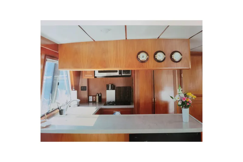 Sumptin Special Yacht Photos Pics Interior of 1990 Ocean Alexander 520 Pilothouse with wooden cabinetry and floral arrangement.