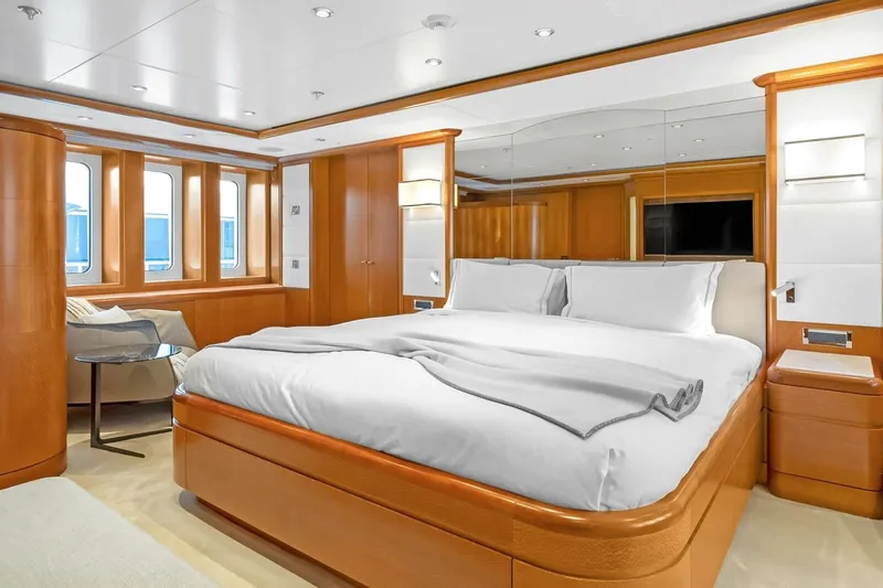 Unforgettable Yacht Photos Pics Luxurious Royal Denship M.Y. 2003 yacht bedroom with elegant wood finishes and large windows.