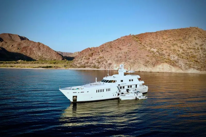 Unforgettable Yacht Photos Pics Luxurious 2003 Royal Denship M.Y. yacht anchored near scenic rocky coastline.