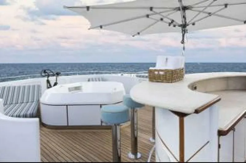 Unforgettable Yacht Photos Pics Luxurious Royal Denship M.Y. 2003 yacht deck with bar, seating, and ocean view.