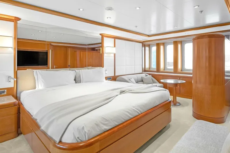 Unforgettable Yacht Photos Pics Luxurious yacht bedroom with elegant wood finishes, large bed, and modern decor, Royal Denship M.Y. 2003.