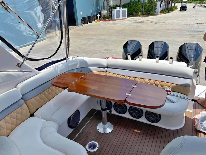  Yacht Photos Pics 2022 Four Winns 238 Vista boat interior with wood table and cushioned seating.