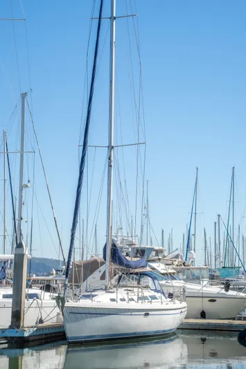 Aries Yacht Photos Pics 2002 Catalina 380 sailboat docked in a marina under a clear blue sky.