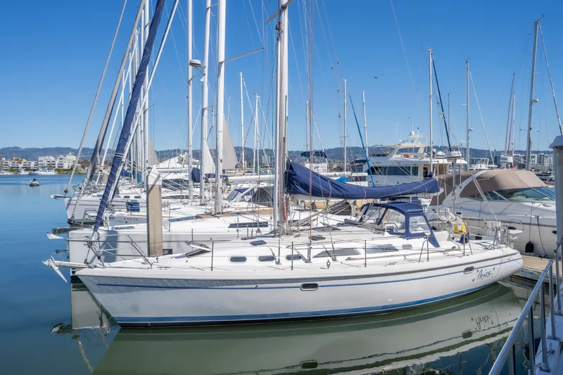 Aries Yacht Photos Pics 2002 Catalina 380 sailboat docked in a marina under clear blue skies.