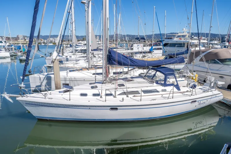 Aries Yacht Photos Pics 2002 Catalina 380 sailboat docked in a marina, surrounded by other boats.
