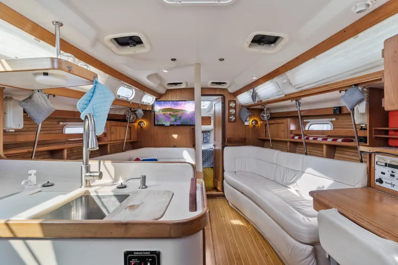 Aries Yacht Photos Pics Interior of 2002 Catalina 380 sailboat with modern kitchen and cozy seating area.