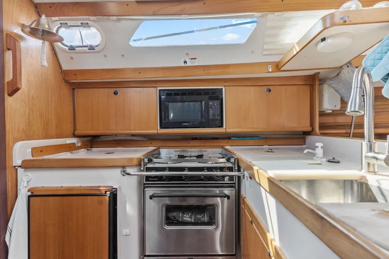 Aries Yacht Photos Pics Interior of 2002 Catalina 380 sailboat kitchen with stove, microwave, and sink.