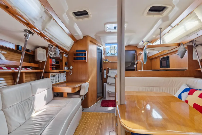 Aries Yacht Photos Pics Interior of 2002 Catalina 380 sailboat with cozy seating and wooden finishes.