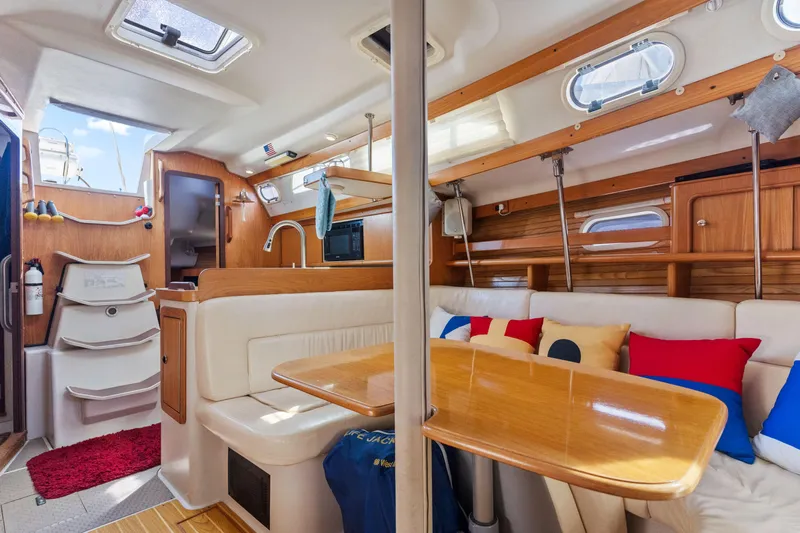 Aries Yacht Photos Pics Interior of a 2002 Catalina 380 sailboat with cozy seating and wooden finishes.