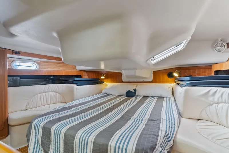 Aries Yacht Photos Pics Interior cabin of a 2002 Catalina 380 sailboat with striped bedding.