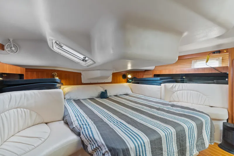 Aries Yacht Photos Pics Luxurious interior of a 2002 Catalina 380 yacht with a spacious, striped bed.