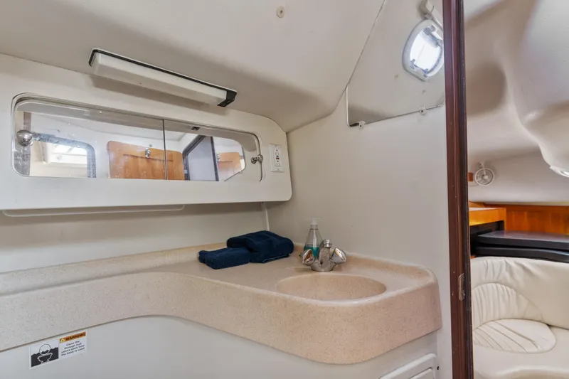 Aries Yacht Photos Pics Interior of 2002 Catalina 380 sailboat bathroom with sink, mirror, and porthole.