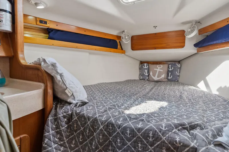 Aries Yacht Photos Pics Cozy cabin interior of 2002 Catalina 380 sailboat with anchor-themed bedding.