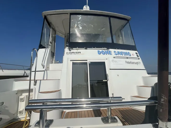  Yacht Photos Pics 2003 Carver 444 Cockpit Motor Yacht, rear view, docked, with "Done Saving" name visible.