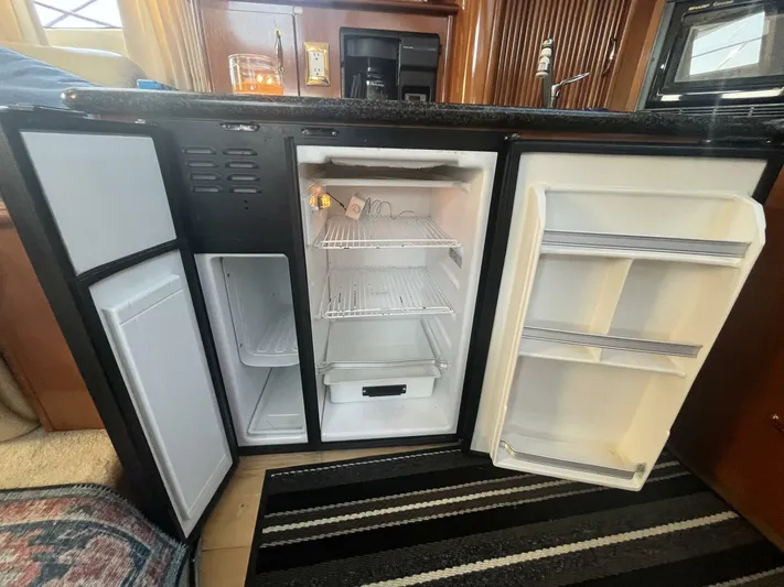  Yacht Photos Pics Open refrigerator in 2003 Carver 444 Cockpit Motor Yacht kitchen, showcasing interior shelves and compartments.