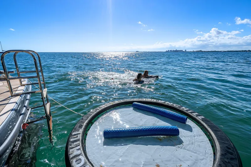 Skip The Wait - Trade Ins Considered Yacht Photos Pics Sunreef 60 Power yacht with swimmers and floating mat on sunny ocean, 2026 model.