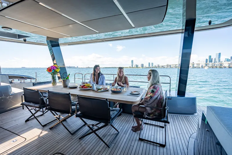 Skip The Wait - Trade Ins Considered Yacht Photos Pics Luxurious Sunreef 60 Power yacht deck with dining area, ocean view, and city skyline.