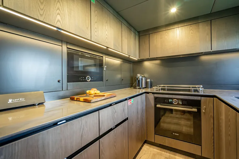 Skip The Wait - Trade Ins Considered Yacht Photos Pics Modern kitchen interior on 2026 Sunreef 60 Power yacht, featuring sleek cabinetry and appliances.