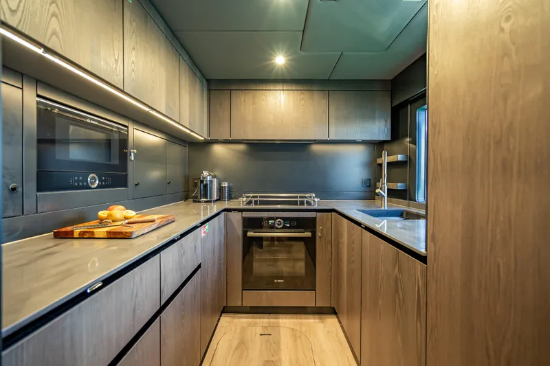 Skip The Wait - Trade Ins Considered Yacht Photos Pics Modern kitchen interior on 2026 Sunreef 60 Power yacht, featuring sleek cabinetry and appliances.