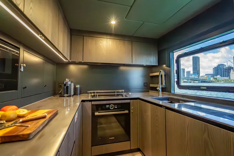 Skip The Wait - Trade Ins Considered Yacht Photos Pics Luxurious kitchen interior of 2026 Sunreef 60 Power yacht with cityscape view.