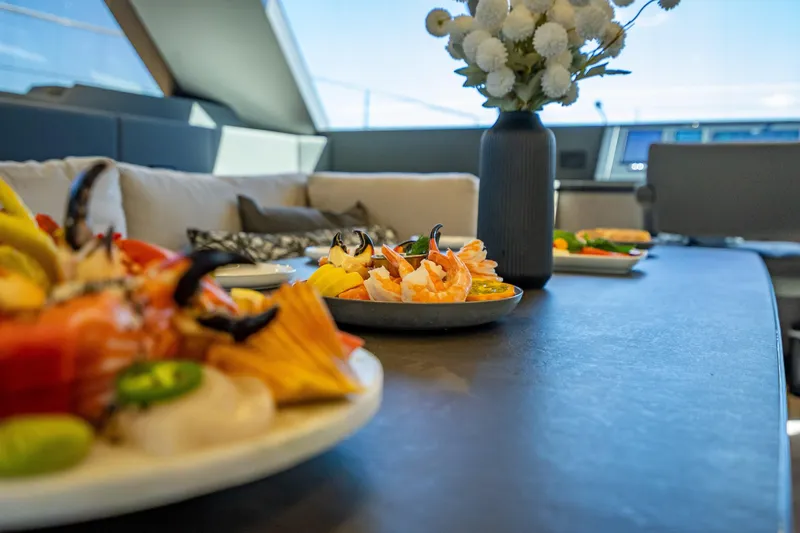 Skip The Wait - Trade Ins Considered Yacht Photos Pics Luxurious dining setup on 2026 Sunreef 60 Power yacht with seafood and elegant decor.