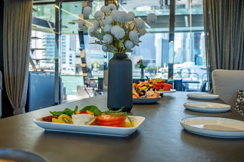 Skip The Wait - Trade Ins Considered Yacht Photos Pics Luxurious dining setup on 2026 Sunreef 60 Power yacht with cityscape view.