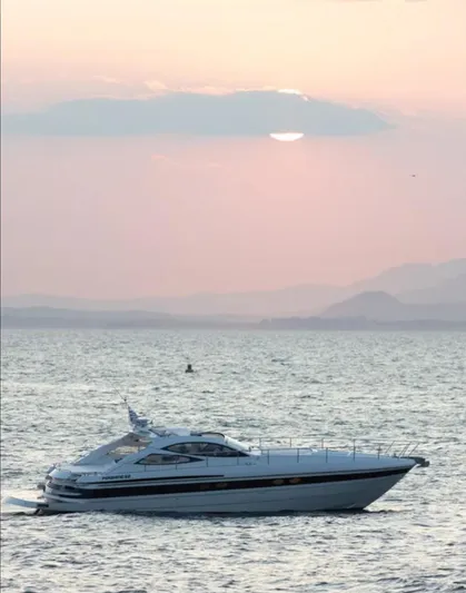 Mira Yacht Photos Pics 2002 Pershing 52' yacht cruising at sunset on calm waters.