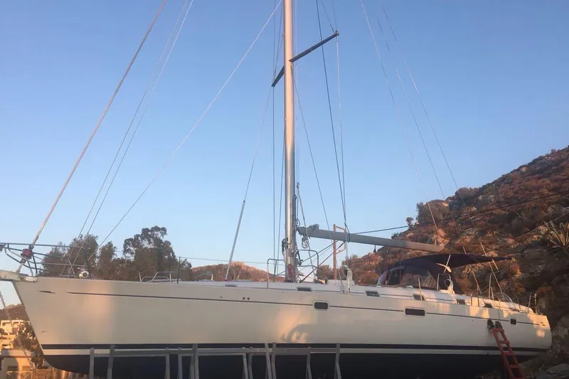  Yacht Photos Pics Sailboat Beneteau 50, 1996 model, on land with scenic mountain backdrop.