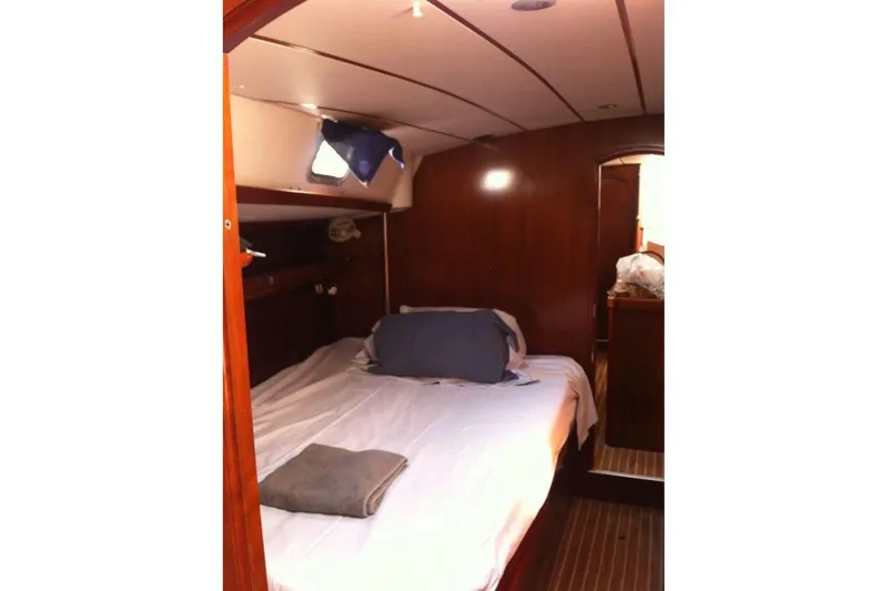  Yacht Photos Pics Cozy cabin interior of 1996 Beneteau 50 sailboat with wooden finish and bed.