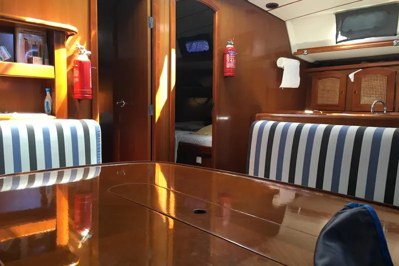  Yacht Photos Pics Interior of a 1996 Beneteau 50 yacht with striped seating and wooden finishes.