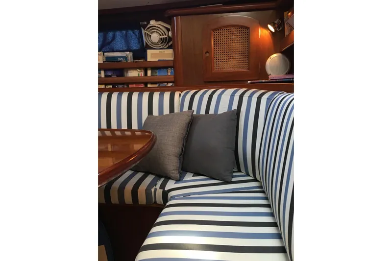  Yacht Photos Pics Striped seating area inside a 1996 Beneteau 50 yacht with cushions and wooden accents.