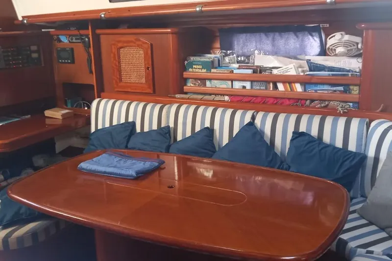  Yacht Photos Pics Interior of a 1996 Beneteau 50 yacht with striped seating and wooden table.