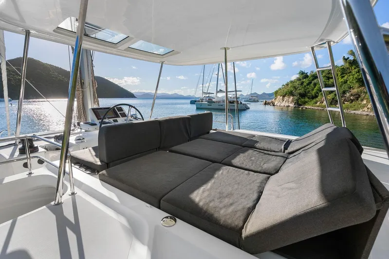 Echo Yacht Photos Pics 2023 Lagoon 50 yacht interior with luxurious seating, overlooking serene waters and distant sailboats.