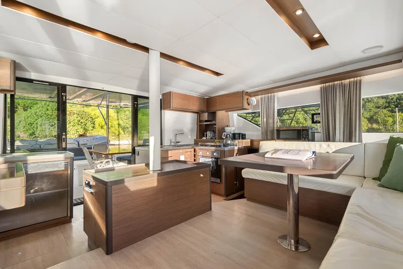Echo Yacht Photos Pics Luxurious interior of 2023 Lagoon 50 catamaran with modern kitchen and seating area.