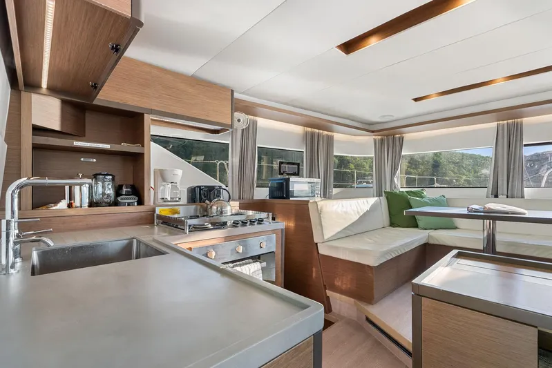 Echo Yacht Photos Pics Modern interior of 2023 Lagoon 50 yacht with kitchen and seating area.