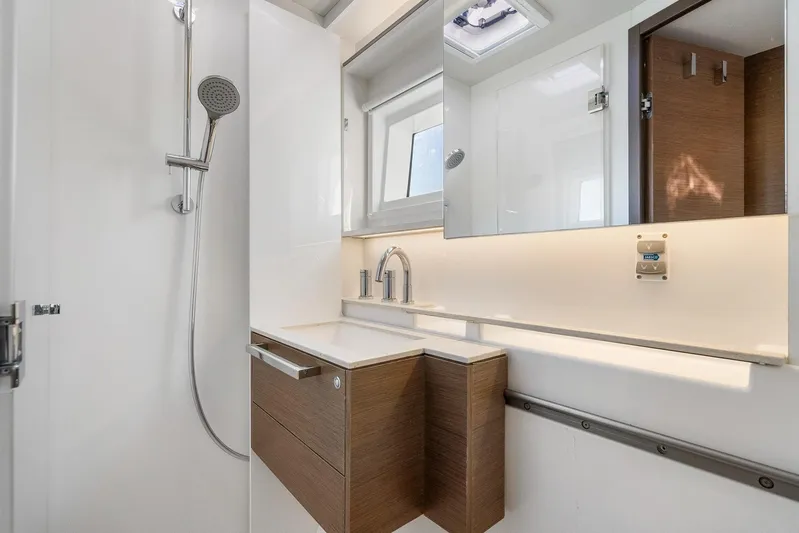Echo Yacht Photos Pics Modern bathroom interior of 2023 Lagoon 50 yacht with sleek fixtures and wooden cabinetry.