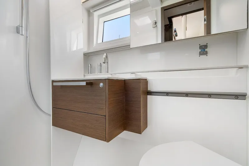 Echo Yacht Photos Pics Modern bathroom interior on 2023 Lagoon 50 yacht, featuring sleek wood cabinetry and fixtures.