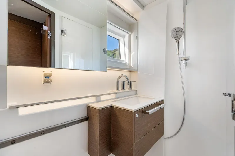 Echo Yacht Photos Pics Modern bathroom in 2023 Lagoon 50 yacht with sleek fixtures and wooden cabinetry.