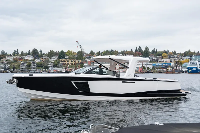  Yacht Photos Pics 2024 Aviara AV40 I/O luxury boat on a scenic waterfront with city backdrop.
